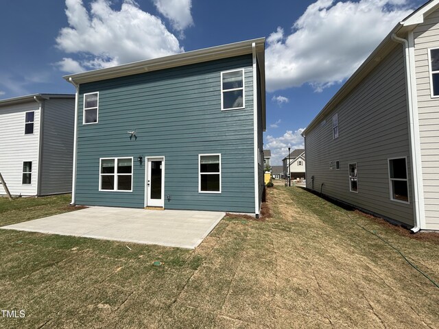 back of property with a patio area and a lawn