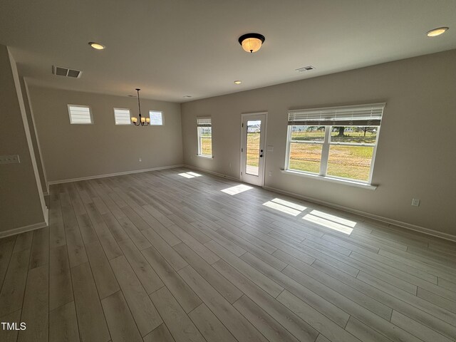 unfurnished dining area with a chandelier, wood finished floors, baseboards, and recessed lighting