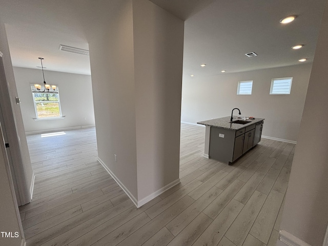 hallway featuring light wood finished floors, baseboards, and recessed lighting