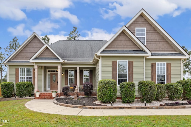 182 Brendamoore Ct, Fuquay Varina, NC 27526 - craftsman-style house with a porch, a front lawn, and roof with shingles