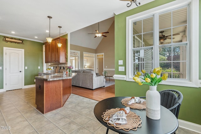 182 Brendamoore Ct, Fuquay Varina, NC 27526 - kitchen featuring a ceiling fan, a peninsula, open floor plan, baseboards, and crown molding