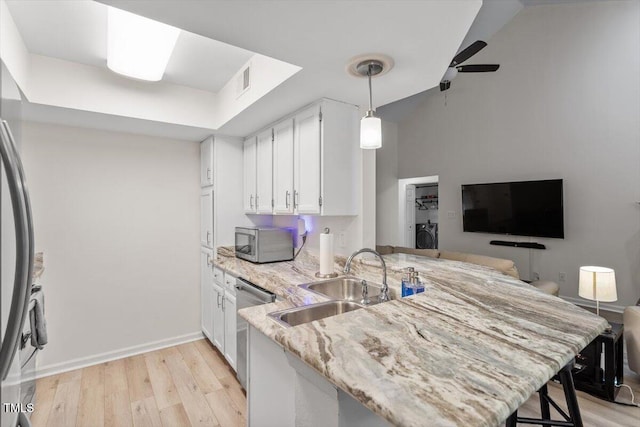 111 Killam Ct Unit 2A, Cary, NC 27513 - kitchen with stainless steel appliances, a sink, a peninsula, light wood-type flooring, and light stone counters