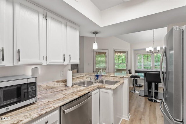 111 Killam Ct Unit 2A, Cary, NC 27513 - kitchen featuring appliances with stainless steel finishes, white cabinetry, a sink, a peninsula, and light wood-style floors