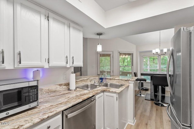 111 Killam Ct Unit 2A, Cary, NC 27513 - kitchen featuring stainless steel appliances, white cabinetry, a sink, a peninsula, and light wood-style floors