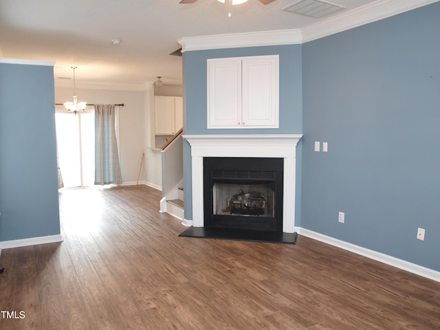unfurnished living room with baseboards, crown molding, a chandelier, wood finished floors, and a ceiling fan