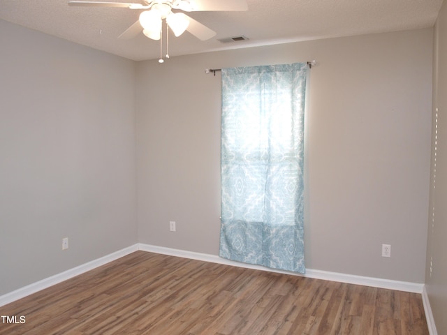 unfurnished room featuring wood finished floors, a ceiling fan, and baseboards