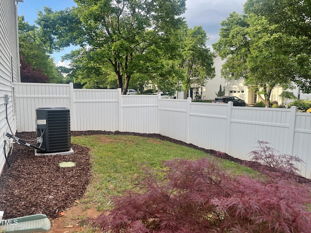 fenced yard featuring central AC unit