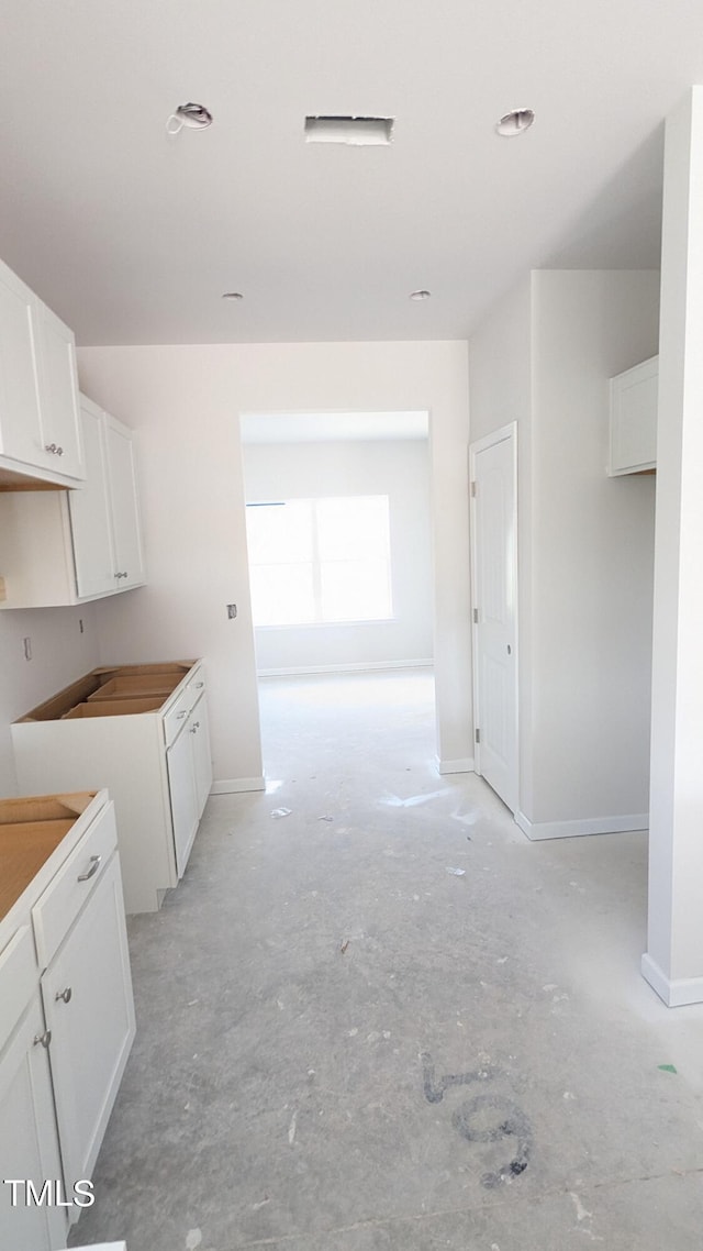 kitchen with white cabinetry and baseboards