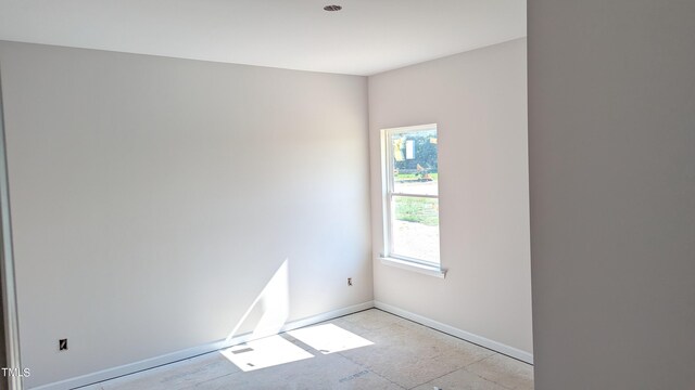 unfurnished room with baseboards
