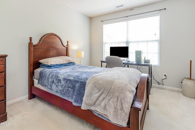bedroom with light colored carpet, multiple windows, and baseboards