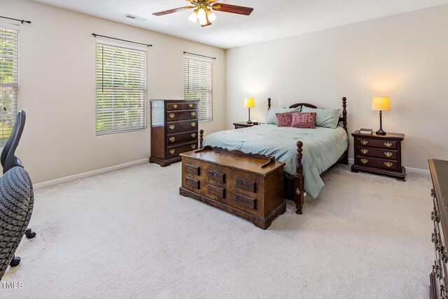 bedroom with light carpet, baseboards, and multiple windows
