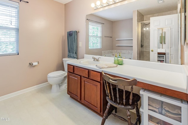 full bath featuring toilet, a shower stall, vanity, and baseboards