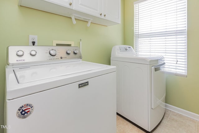 laundry room featuring cabinet space, separate washer and dryer, light tile patterned flooring, and baseboards