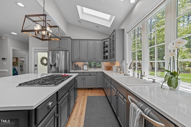 120 Harmony Hill Ln, Cary, NC 27513 - kitchen with appliances with stainless steel finishes, gray cabinetry, a sink, a skylight, and light wood-style floors
