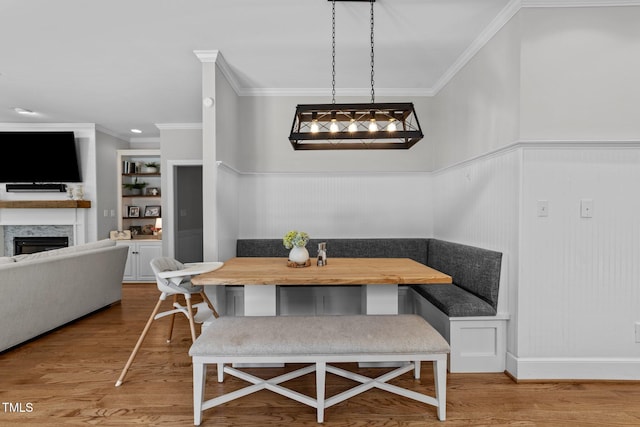 120 Harmony Hill Ln, Cary, NC 27513 - dining room featuring breakfast area, a premium fireplace, wood finished floors, crown molding, and wainscoting