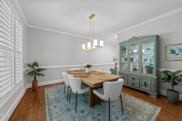 120 Harmony Hill Ln, Cary, NC 27513 - dining area featuring crown molding, a chandelier, dark wood-type flooring, and baseboards