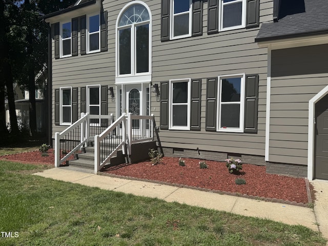 view of front of home featuring crawl space, a garage, and a front yard
