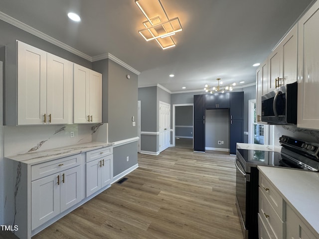 kitchen featuring stainless steel microwave, black electric range oven, a chandelier, recessed lighting, and crown molding