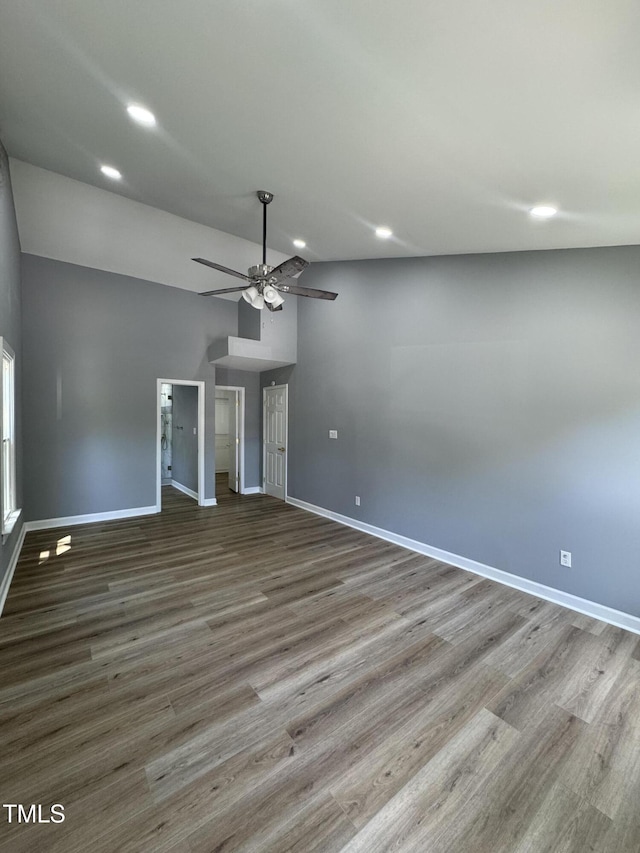 unfurnished living room featuring baseboards, ceiling fan, wood finished floors, recessed lighting, and lofted ceiling