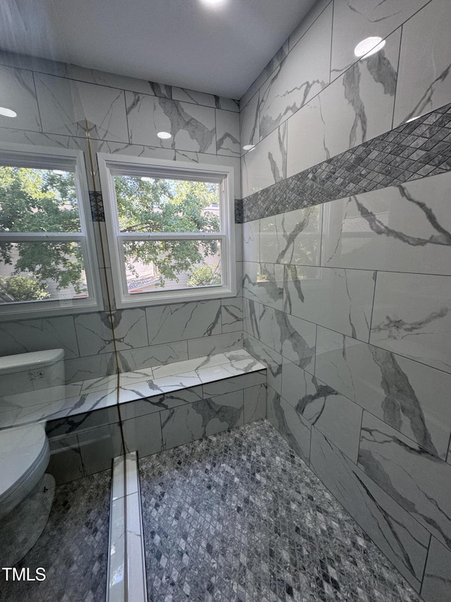 full bath featuring healthy amount of natural light, tiled shower, and toilet