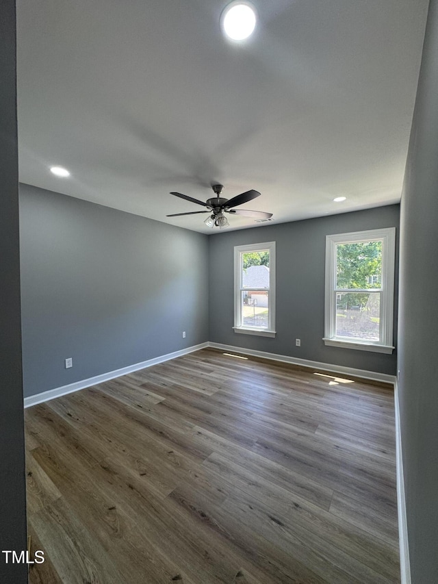 spare room featuring baseboards, dark wood finished floors, a ceiling fan, and recessed lighting