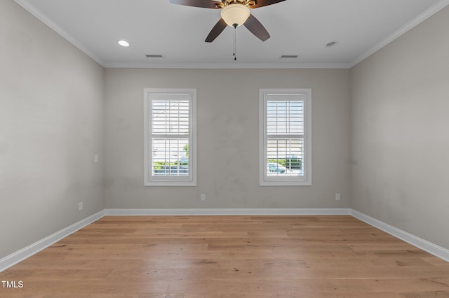 spare room with plenty of natural light, crown molding, light wood-style floors, ceiling fan, and baseboards