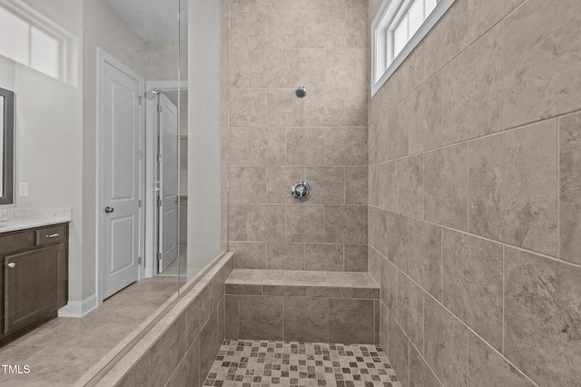 bathroom featuring a tile shower and vanity