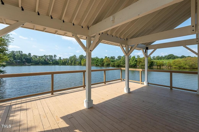 dock featuring a deck with water view and view of scattered trees