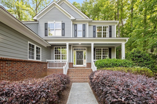 view of front facade featuring covered porch and brick siding