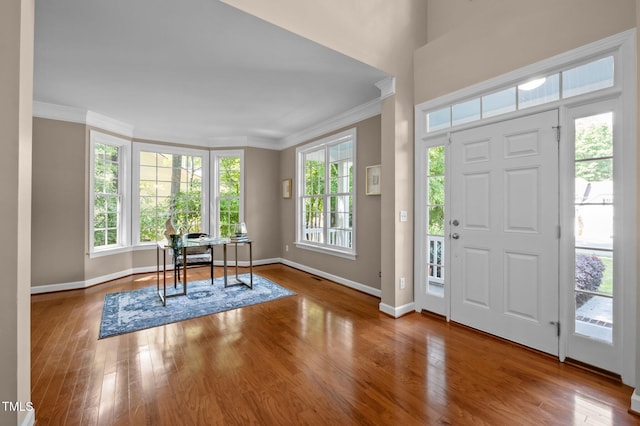 entryway featuring ornamental molding, baseboards, and wood finished floors