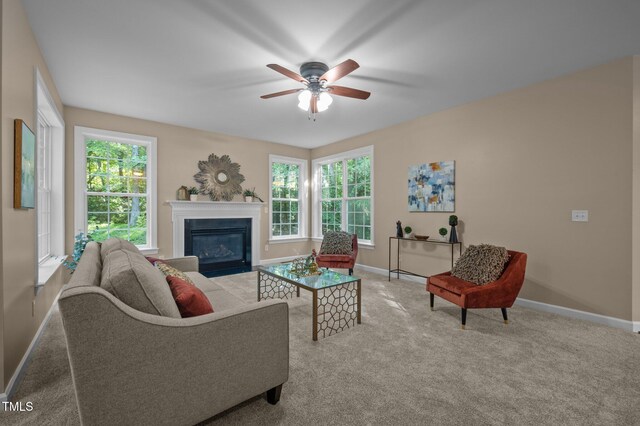 carpeted living room with baseboards, ceiling fan, and a fireplace with flush hearth