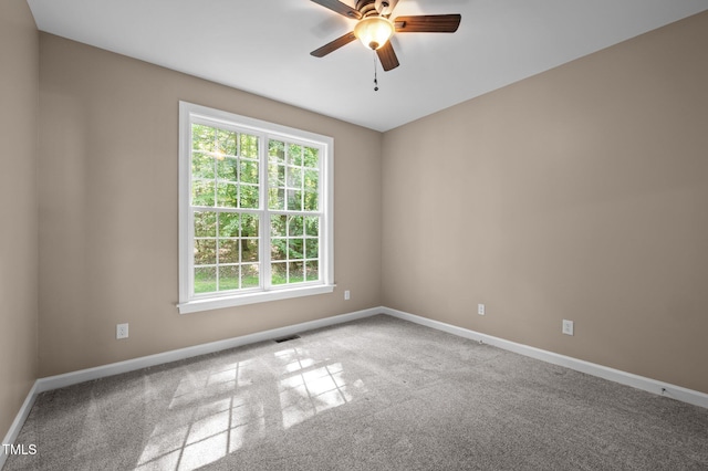 spare room featuring carpet floors, a ceiling fan, and baseboards
