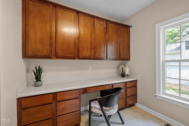 office space featuring built in study area, baseboards, and light tile patterned flooring