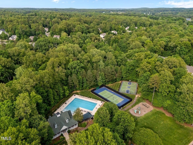 drone / aerial view of a forest and a pool area