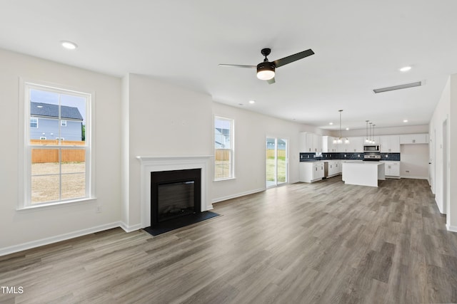 50 Rosewood Ln, Youngsville, NC 27596 - unfurnished living room with wood finished floors, a ceiling fan, plenty of natural light, recessed lighting, and baseboards