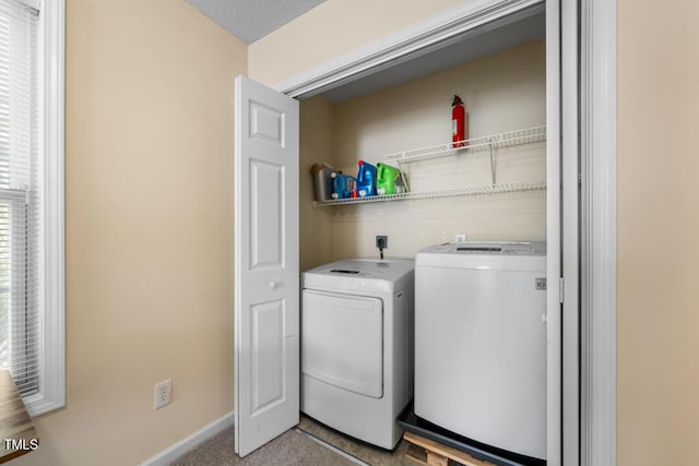 laundry room featuring separate washer and dryer, baseboards, and light carpet