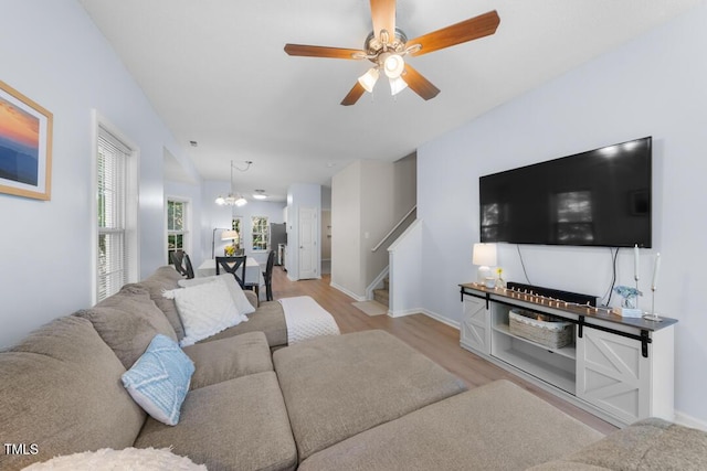 living area with stairway, wood finished floors, a ceiling fan, and baseboards