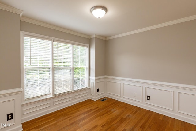 716 Lakeview Ave, Wake Forest, NC 27587 - spare room featuring light wood-style flooring, crown molding, a wainscoted wall, and a decorative wall