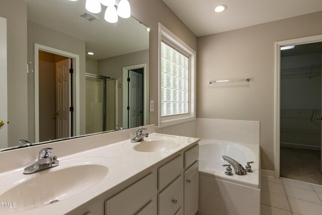 716 Lakeview Ave, Wake Forest, NC 27587 - bathroom featuring a garden tub, tile patterned floors, a shower stall, double vanity, and a spacious closet