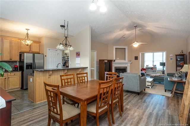 3024 Metthame Dr, Fayetteville, NC 28306 - dining space with vaulted ceiling, a fireplace, a ceiling fan, and dark wood-style floors