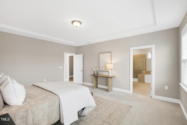 bedroom with light colored carpet, baseboards, connected bathroom, and multiple windows