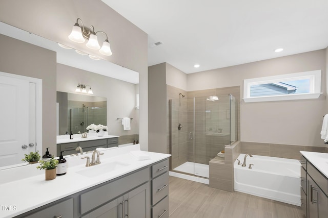 full bath featuring a shower stall, a bath, vanity, and recessed lighting