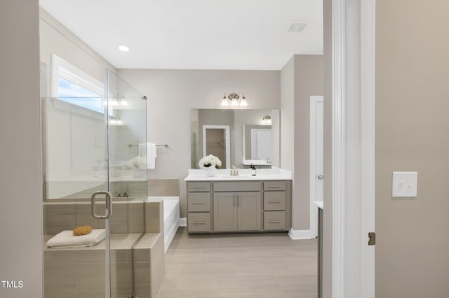 bathroom featuring a stall shower, a bath, vanity, tile patterned floors, and baseboards