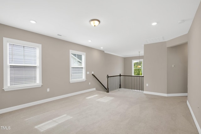 empty room featuring light colored carpet, baseboards, and recessed lighting