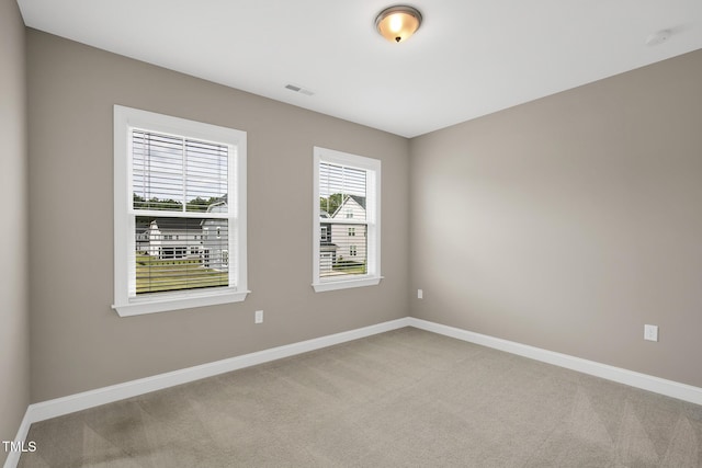 unfurnished room with carpet floors and baseboards