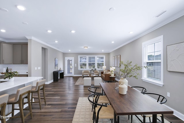 dining room with recessed lighting, plenty of natural light, dark wood-type flooring, baseboards, and ornamental molding