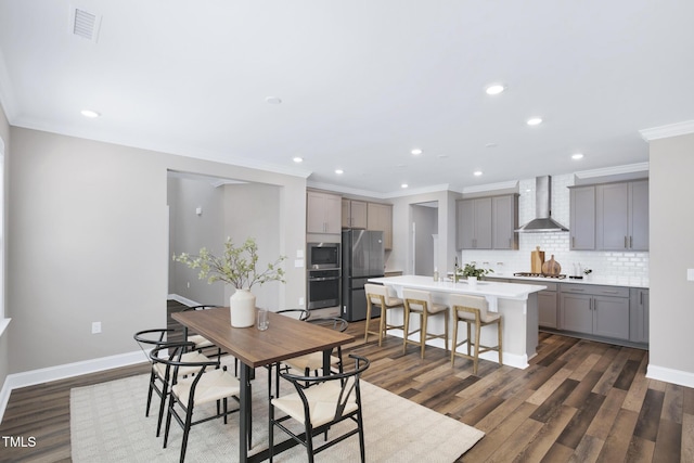 dining room featuring dark wood-type flooring, ornamental molding, recessed lighting, and baseboards