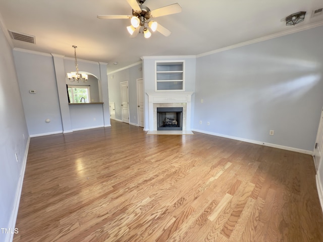 unfurnished living room with a chandelier, a ceiling fan, ornamental molding, and wood finished floors