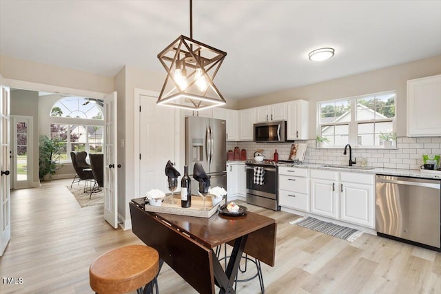 1969 Bowles Ave, Creedmoor, NC 27522 - kitchen with stainless steel appliances, a sink, light wood-type flooring, and decorative backsplash