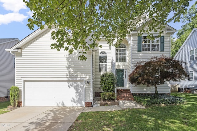 traditional home with concrete driveway, a front yard, and an attached garage